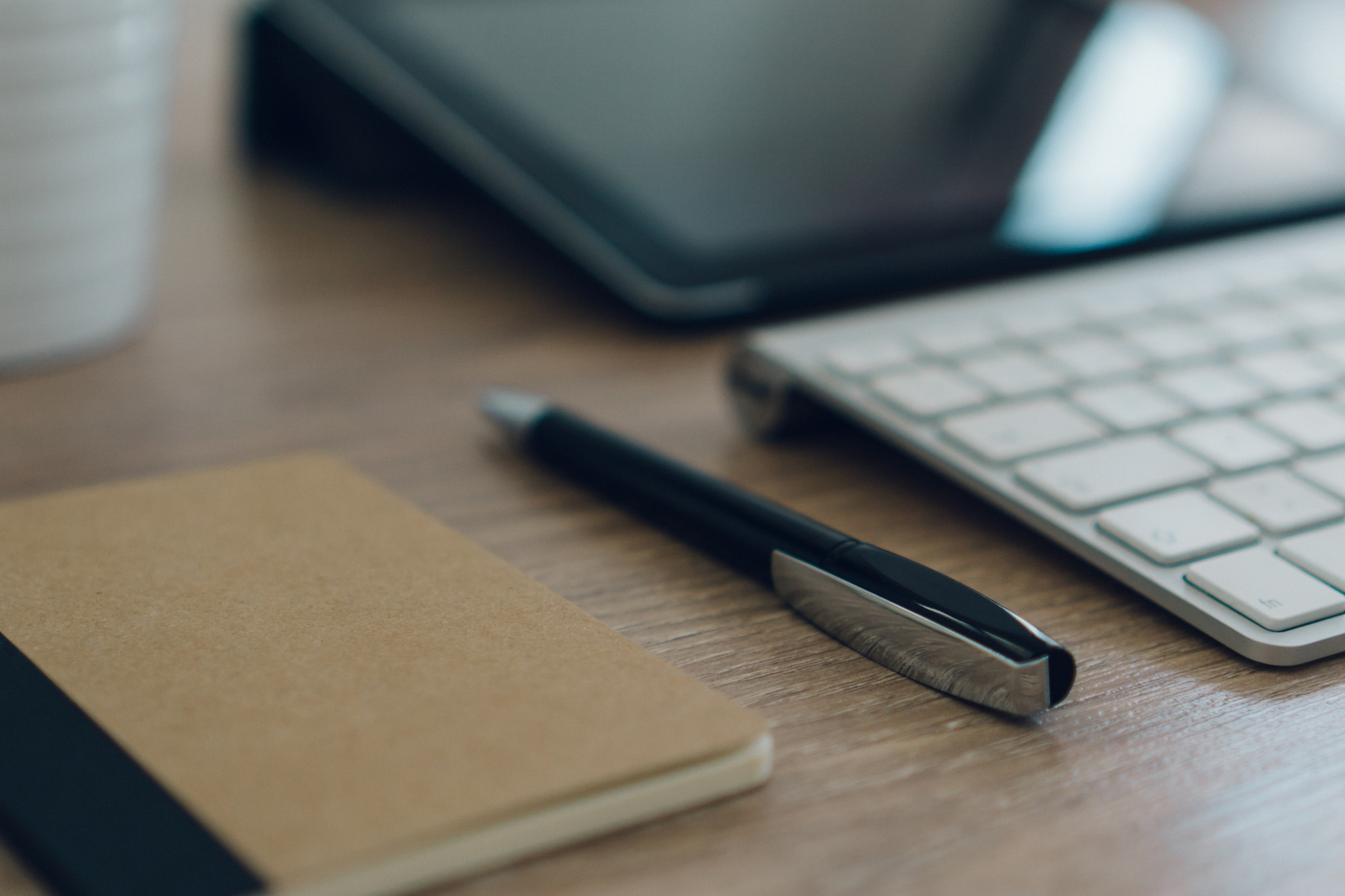 Secretária com caneta, caderno e teclado